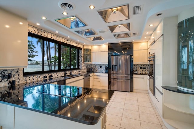 kitchen featuring sink, light tile floors, white cabinets, stainless steel appliances, and coffered ceiling