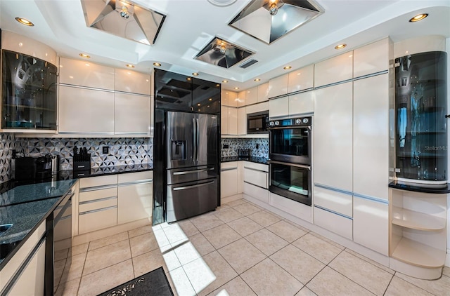 kitchen with light tile floors, white cabinets, backsplash, and black appliances