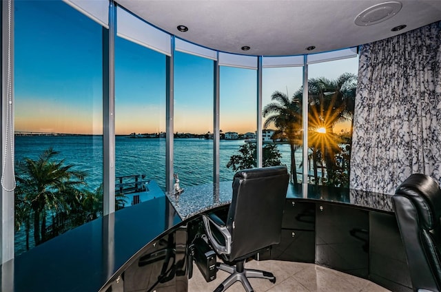 tiled home office featuring expansive windows and a water view