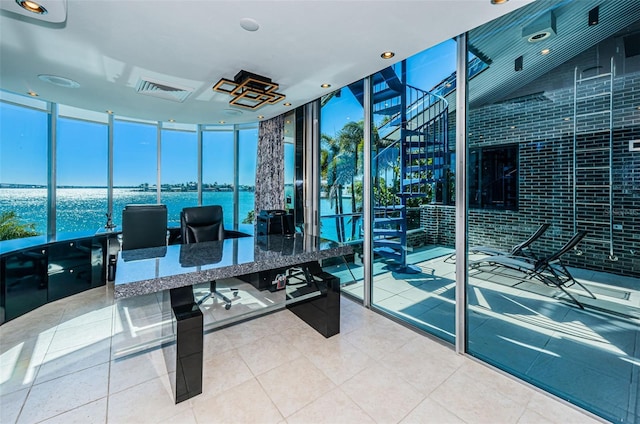 interior space with a water view, expansive windows, and light tile floors