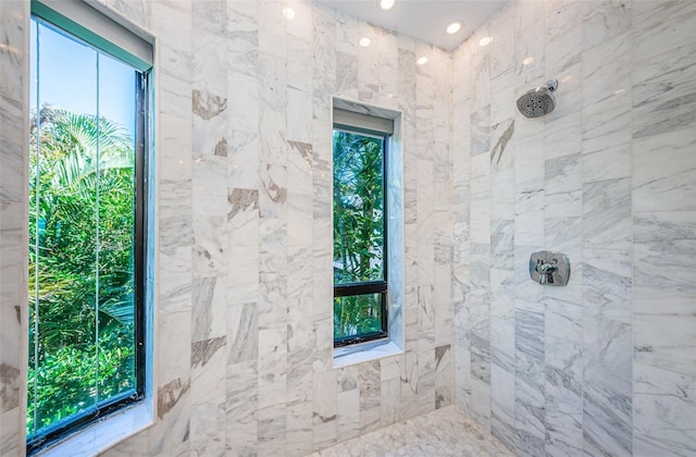 bathroom featuring plenty of natural light and tiled shower