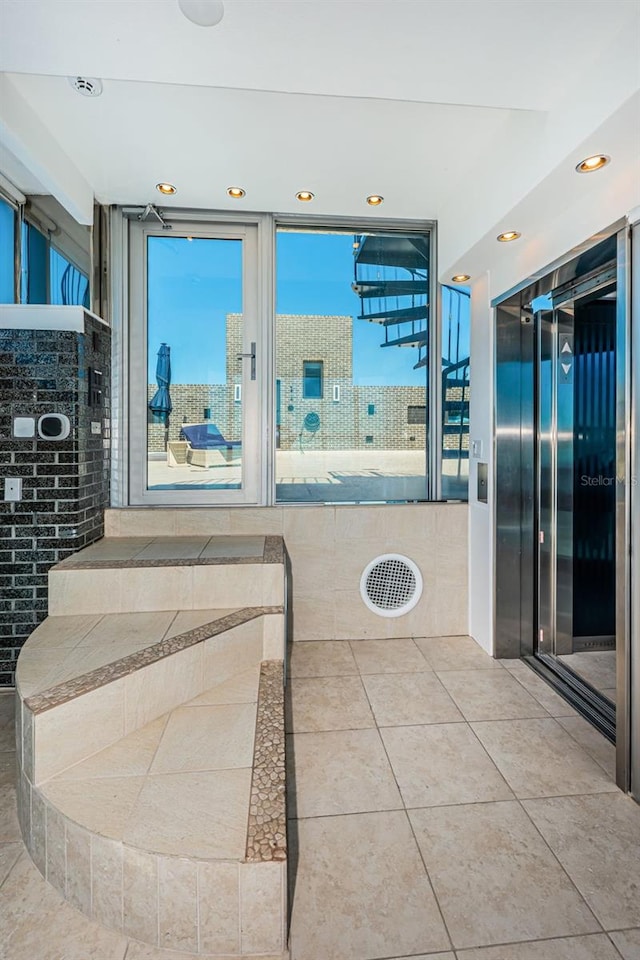 interior space with elevator and light tile flooring