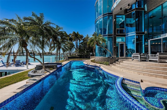 view of swimming pool featuring a water view and a patio area