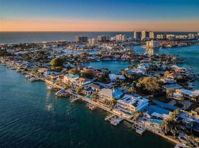 aerial view at dusk with a water view and a view of city