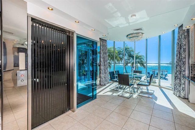 interior space featuring visible vents, floor to ceiling windows, and tile patterned floors