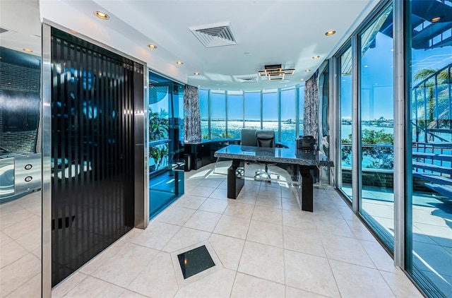 tiled office space with visible vents, a wall of windows, and recessed lighting