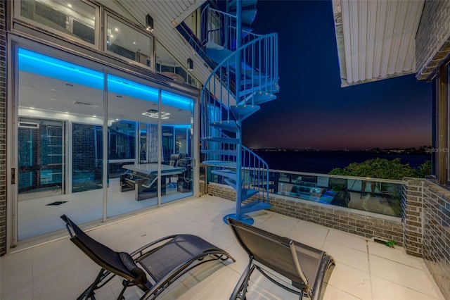 view of patio featuring stairs and a balcony