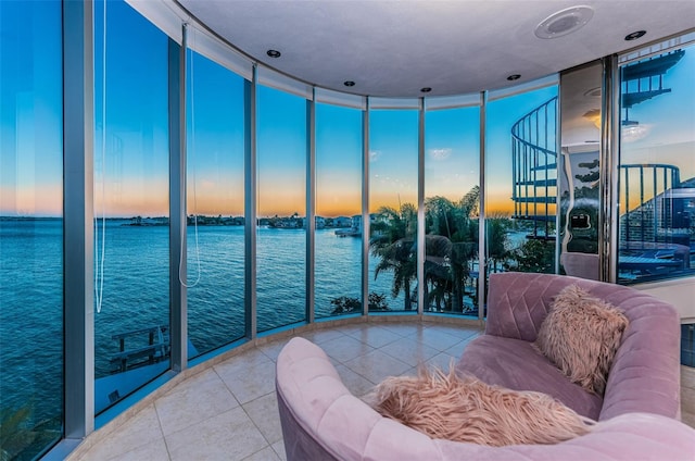 living room featuring tile patterned flooring, floor to ceiling windows, and a water view