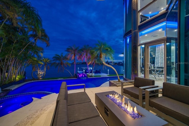 pool at twilight with an outdoor pool, an outdoor living space with a fire pit, a patio, and an in ground hot tub