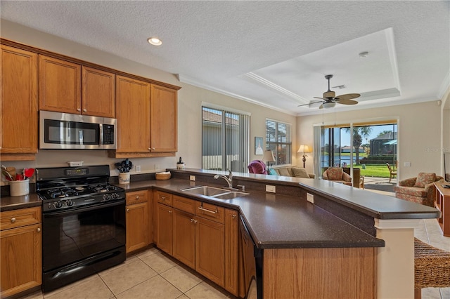 kitchen featuring a raised ceiling, kitchen peninsula, sink, and black appliances