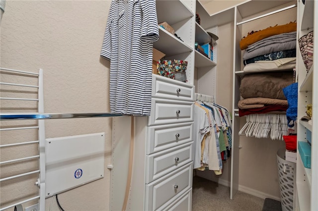 walk in closet featuring dark colored carpet