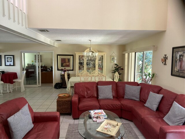 living room featuring a textured ceiling, light tile patterned floors, and a notable chandelier