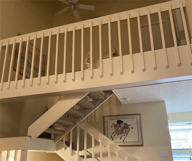 stairs with a high ceiling and ceiling fan