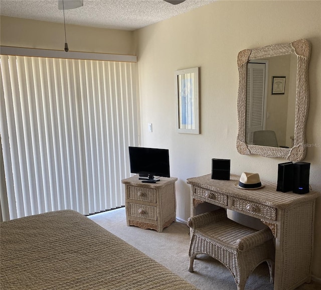 bedroom featuring a textured ceiling and light carpet