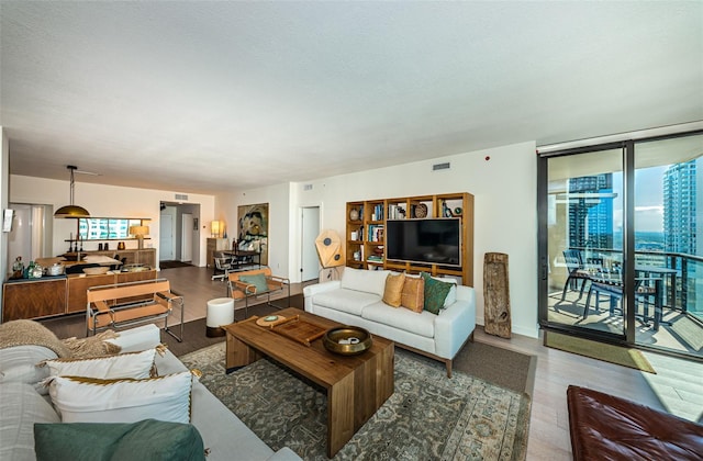 living room with dark hardwood / wood-style floors and expansive windows