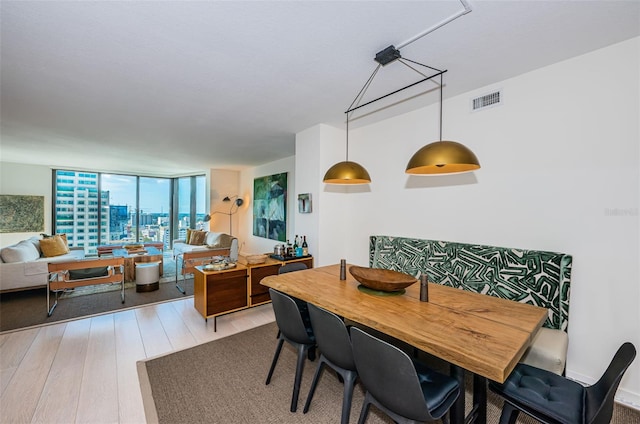 dining room featuring light hardwood / wood-style floors and a wall of windows