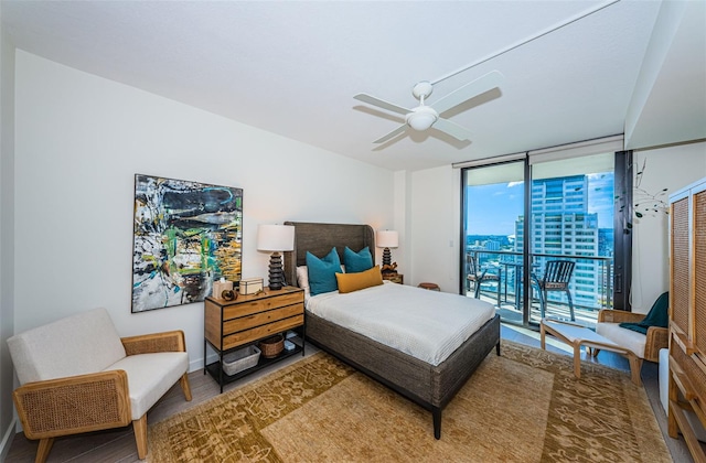 bedroom with access to outside, ceiling fan, and a wall of windows