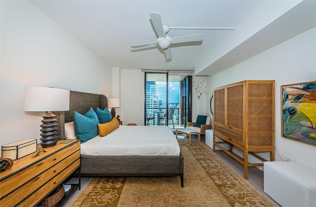 bedroom featuring expansive windows, ceiling fan, access to outside, and hardwood / wood-style flooring