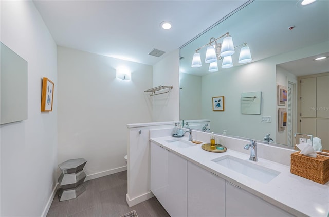 bathroom with tile floors, toilet, and dual bowl vanity