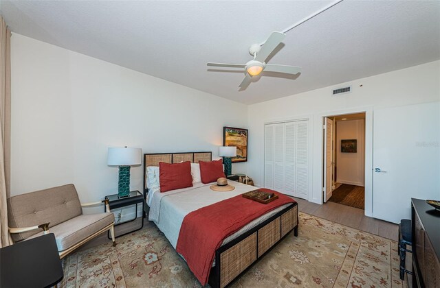 bedroom with a closet, ceiling fan, and light wood-type flooring