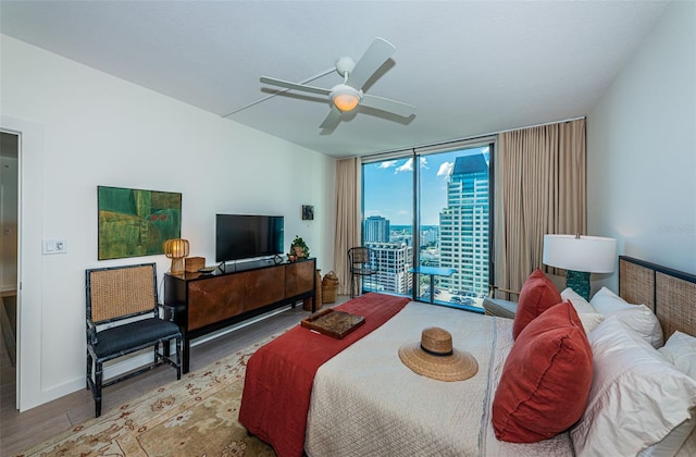 bedroom featuring expansive windows, ceiling fan, light hardwood / wood-style floors, and access to outside