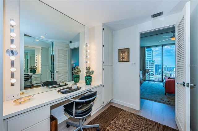 home office with light hardwood / wood-style flooring and ceiling fan