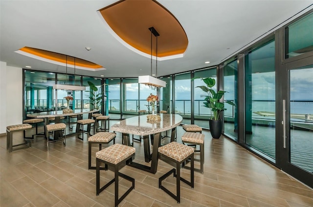 dining room with a wall of windows and a raised ceiling