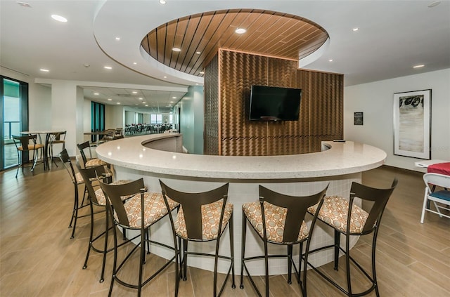 bar featuring wooden ceiling and light hardwood / wood-style flooring