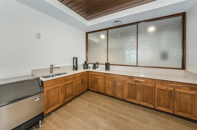 kitchen with light stone countertops, wood ceiling, sink, and light wood-type flooring