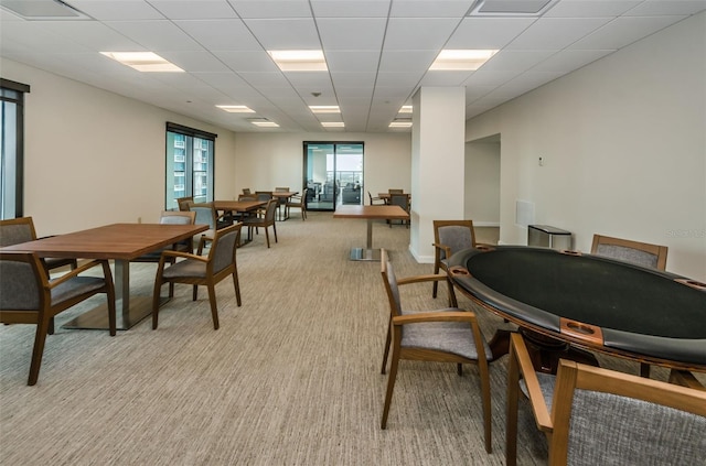 carpeted dining space featuring a drop ceiling