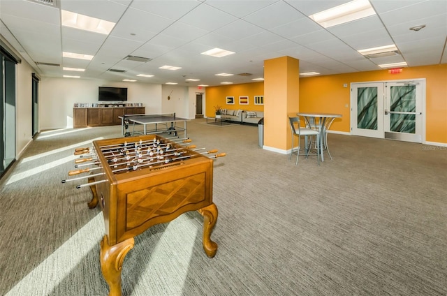 recreation room with french doors, light colored carpet, and a drop ceiling