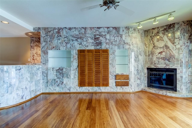 unfurnished living room featuring light hardwood / wood-style floors, ceiling fan, and track lighting