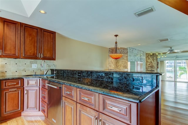 kitchen featuring light hardwood / wood-style flooring, decorative light fixtures, ceiling fan, and dark stone counters