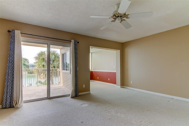 carpeted empty room featuring ceiling fan and a textured ceiling