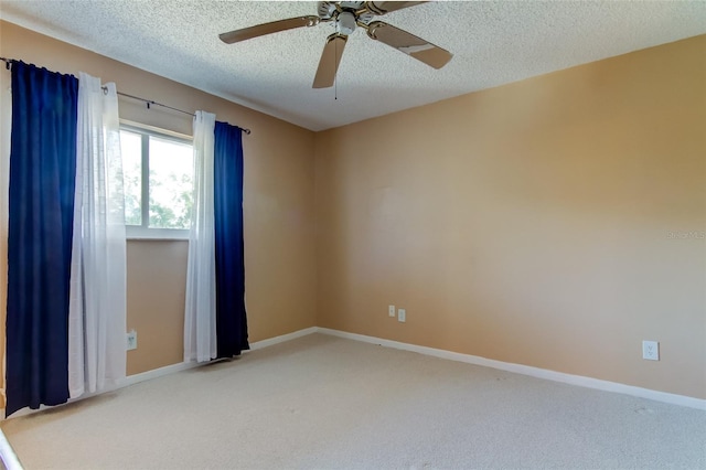 carpeted spare room with a textured ceiling and ceiling fan