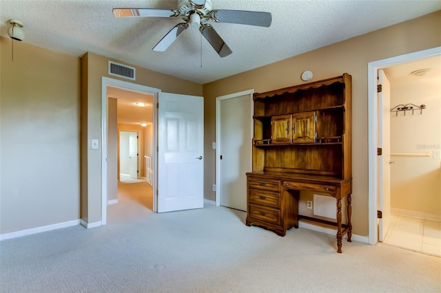 carpeted bedroom featuring ceiling fan and a textured ceiling