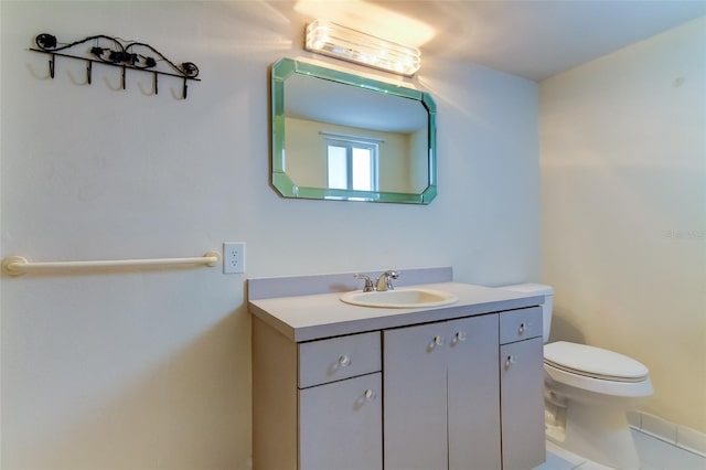 bathroom featuring toilet, vanity with extensive cabinet space, and tile flooring