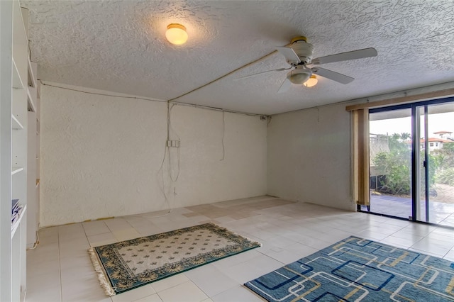 tiled spare room featuring ceiling fan and a textured ceiling