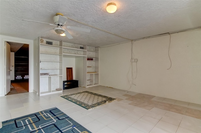 interior space with light tile flooring, built in features, ceiling fan, and a textured ceiling