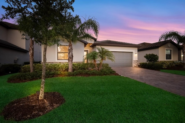 view of front of home with a yard and a garage