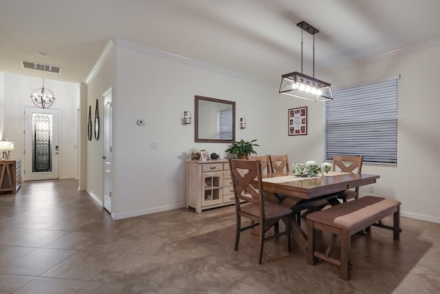 tiled dining area with crown molding and an inviting chandelier