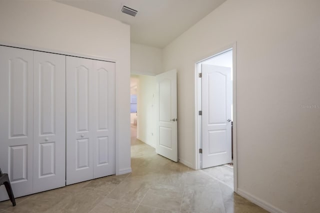 unfurnished bedroom featuring a closet and light tile floors