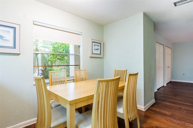 dining space featuring a textured ceiling and dark hardwood / wood-style floors