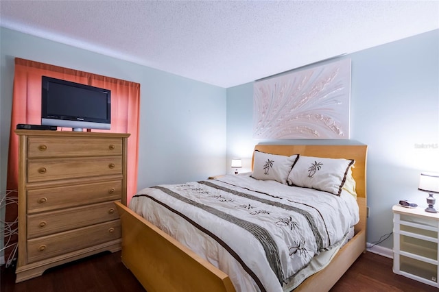 bedroom featuring dark hardwood / wood-style flooring and a textured ceiling