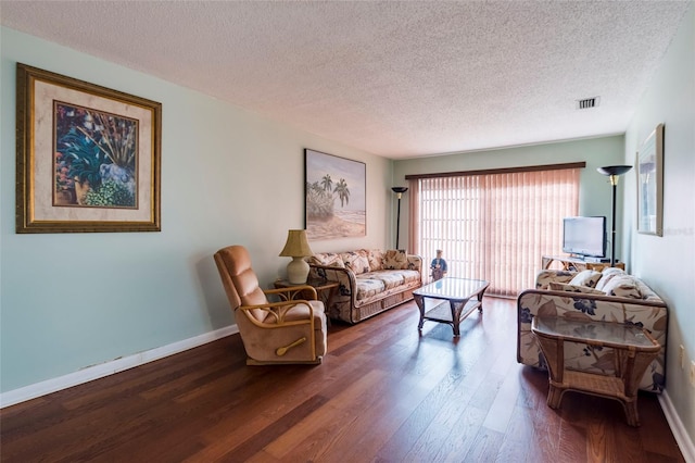 living room featuring a textured ceiling and dark hardwood / wood-style flooring