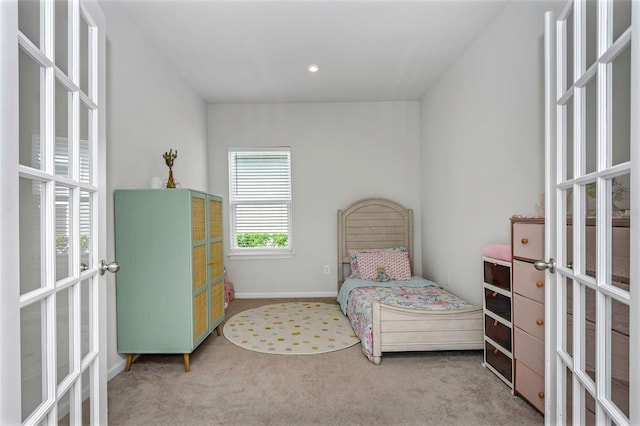 bedroom with light colored carpet and french doors