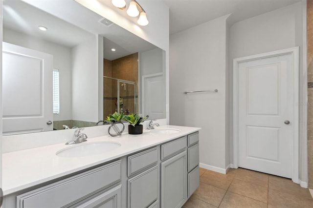 bathroom featuring tile patterned flooring, vanity, and a shower with shower door