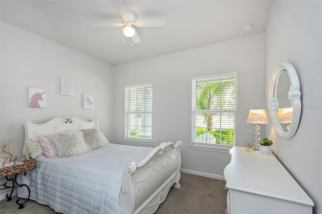 carpeted bedroom featuring baseboards, multiple windows, and a ceiling fan