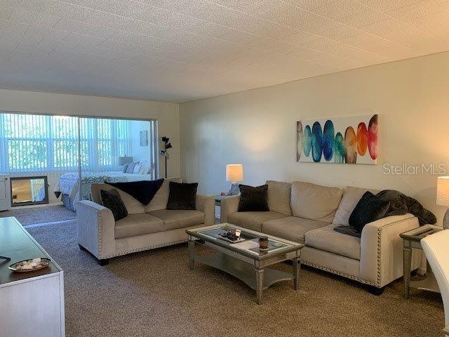 carpeted living room featuring a textured ceiling