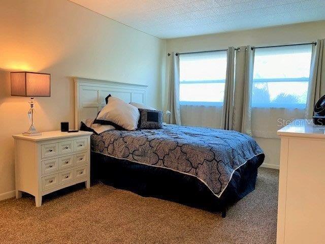 bedroom featuring a textured ceiling and light colored carpet